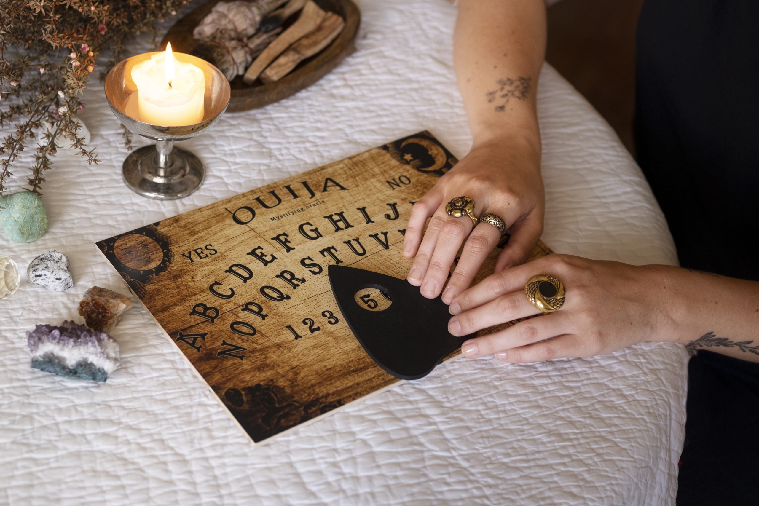 hands using old wooden ouija board high angle scaled