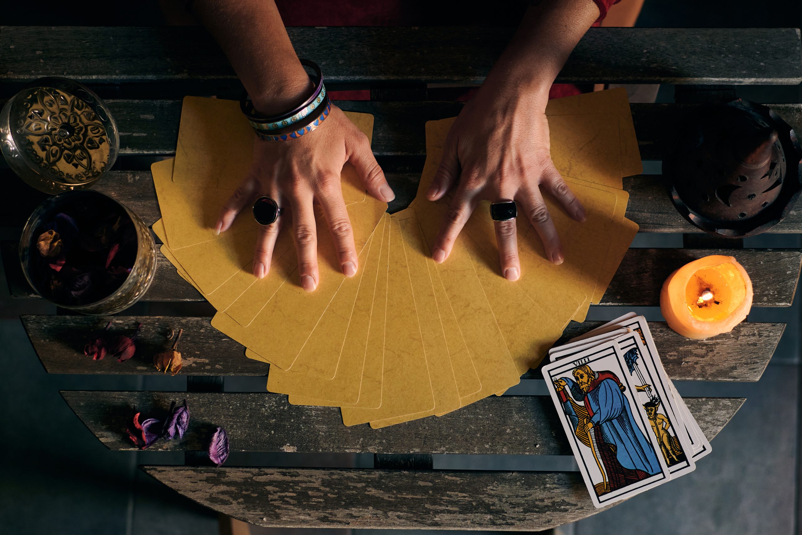 close up fortune teller displaying some tarot cards wooden table scaled