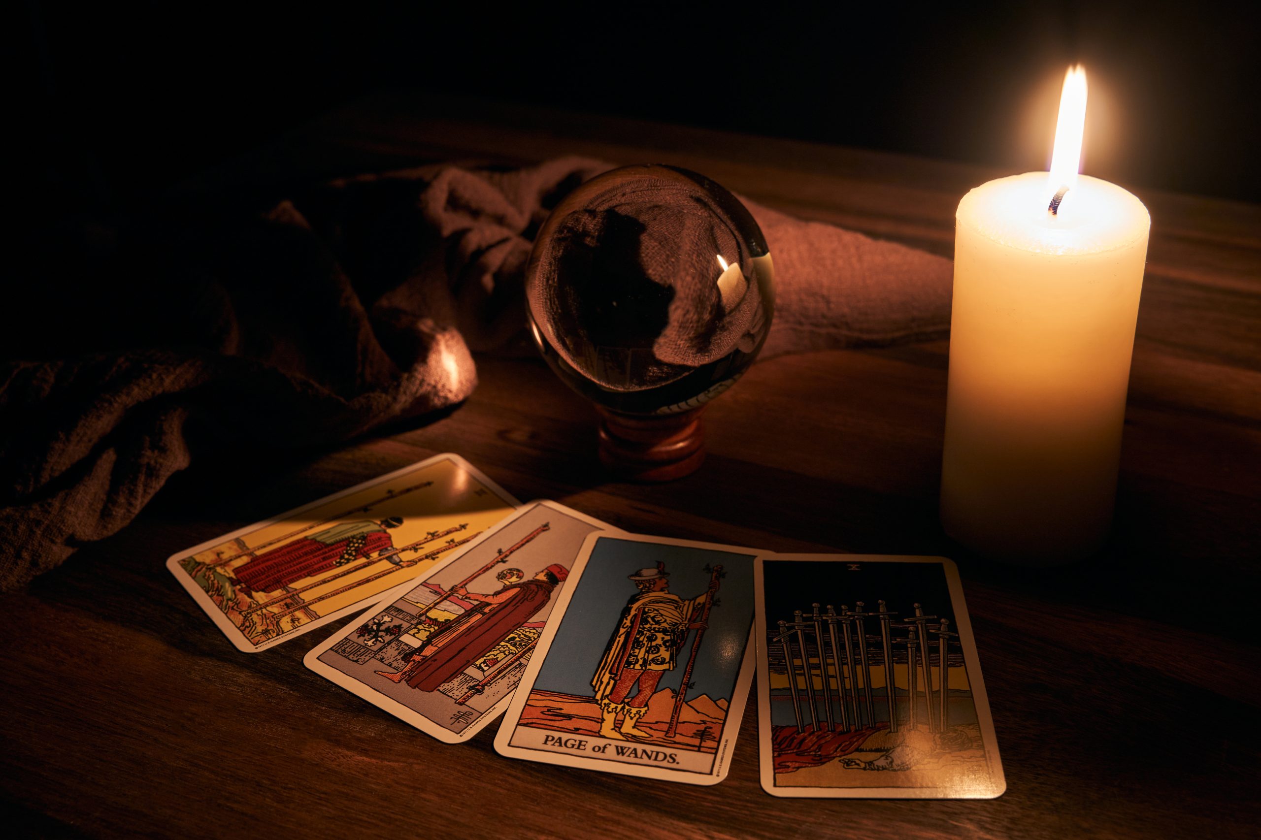 fortune telling wooden table white candle with crystal ball tarot cards background scaled